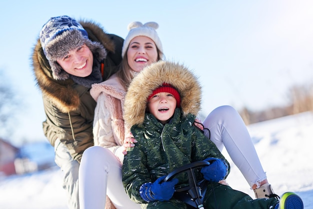 Zdjęcie miła szczęśliwa rodzina bawi się na śniegu. zdjęcie wysokiej jakości