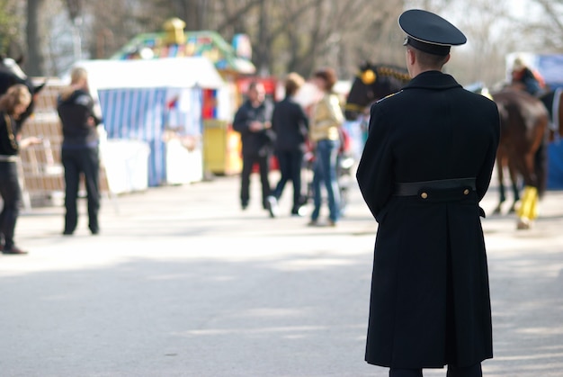 Militarny Mężczyzna Patrząc Na Idących Ludzi