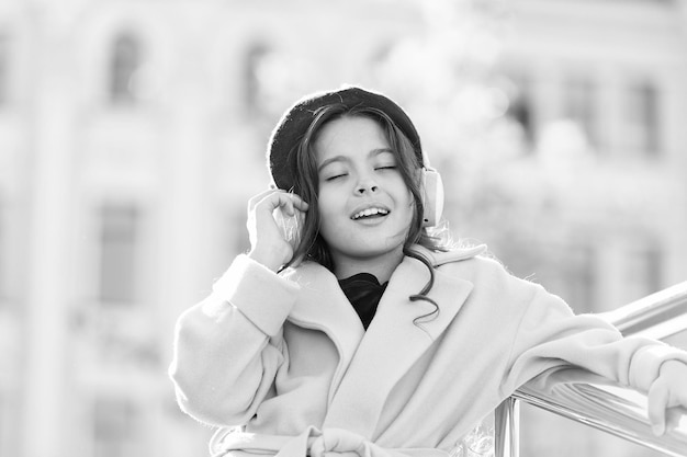 Miłośnik muzyki zainspirowany mała dziewczynka dziecko słuchaj książki audio mała dziewczynka w zestawie słuchawkowym edukacja online ebook technologia wesoła paryska dziewczyna we francuskim berecie jesień moda szkoła jesień sezon