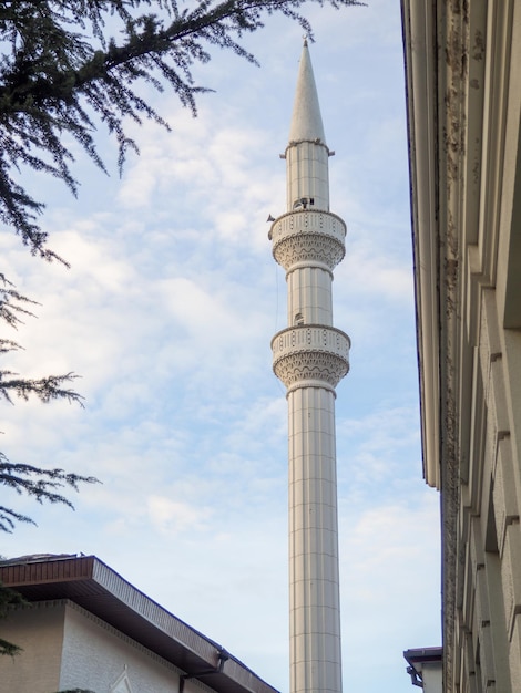 Minaret meczetu wznosi się nad budynkami meczetu pod ostrym kątem islam