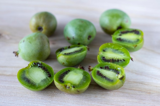 Mini kiwi actinidia na drewnianej desce przeciętej na pół selektywnej ostrości