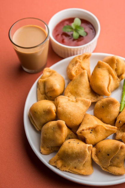 Mini lub mała samosa z sosem i gorącą herbatą