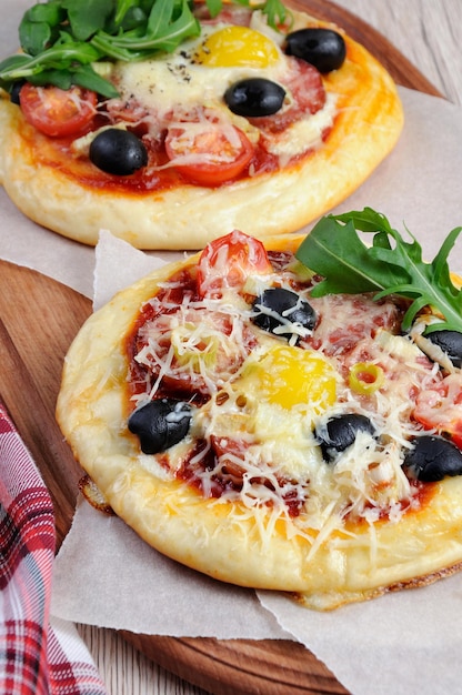 Mini pizza z kiełbasą i jajkiem i rukolą na śniadanie