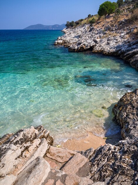 Mini plaża i klapki z widokiem na wyspę Kefalonia na Morzu Jońskim w Grecji