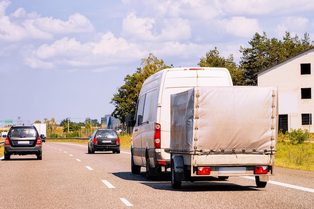 Zdjęcie mini van z przyczepą samochodową na jezdni w polsce.