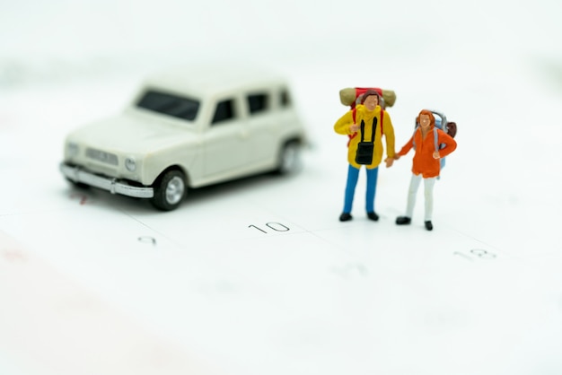 Miniatura Turystów Z Plecakami Stojącymi W Kalendarzu Podróży