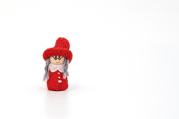 Miniaturowa gnom babcia w czerwonym kapeluszu z warkoczem odizolowywającym na bielu i