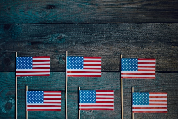 Miniaturowa papierowa flaga USA. Flaga Amerykańska na nieociosanym drewnianym tle.