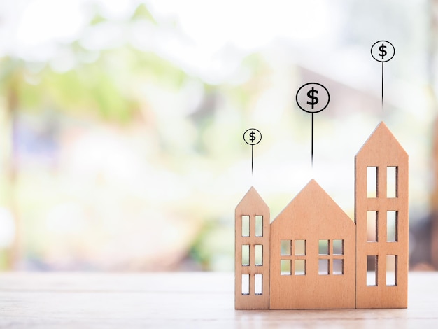 Miniaturowe domy i ikony monet dolarowych Koncepcja ceny domu Inwestycja nieruchomości Hipoteka domu Nieruchomości