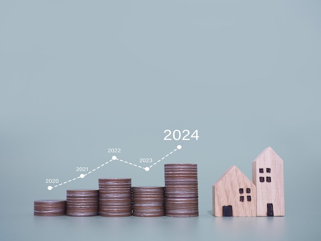 Miniaturowe domy i stosy monet z wirtualnym wzrastającym wykresem Koncepcja o cenie domu rośnie Inwestycje nieruchomości Hipoteka domu Nieruchomości w roku 2024