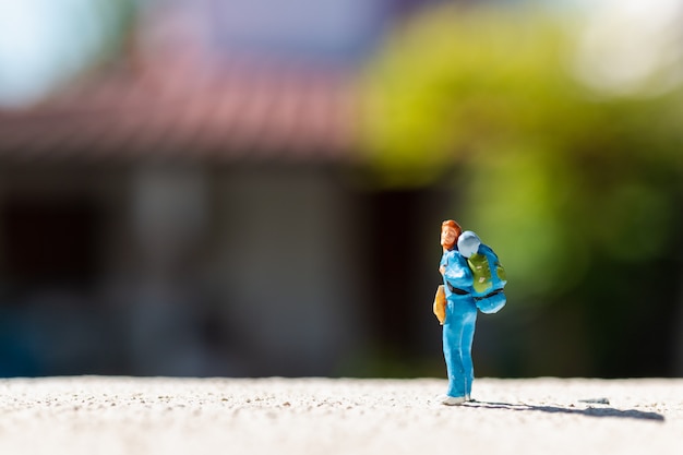 Miniaturowe Osoby: Podróżnik Z Plecakiem Stojącym Na Drodze