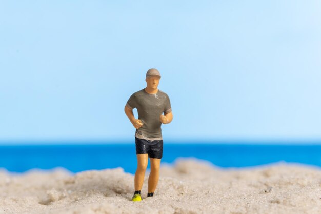 Miniaturowi ludzie biegający po plaży