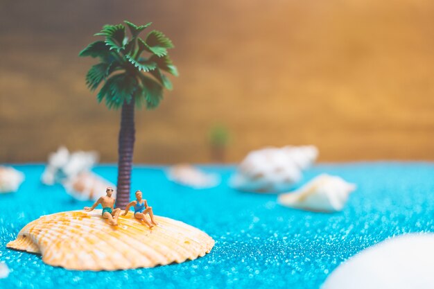 Miniaturowi Ludzie Jest Ubranym Swimsuit Relaksuje Na Seashell