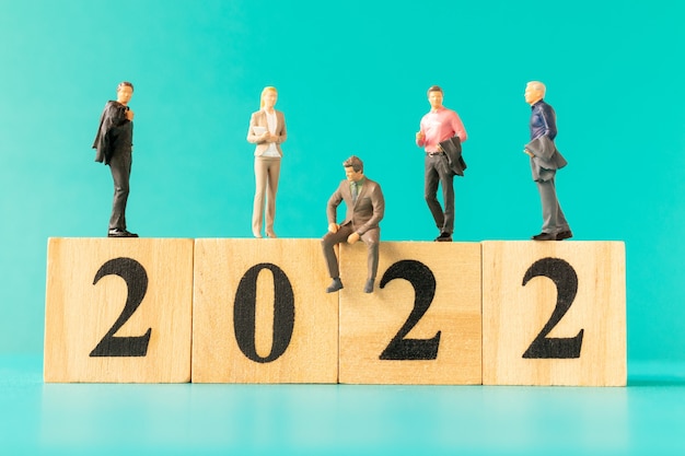 Miniaturowi Ludzie: Ludzie Biznesu Stojący Na Drewnianym Bloku Numer 2022, Koncepcja Szczęśliwego Nowego Roku