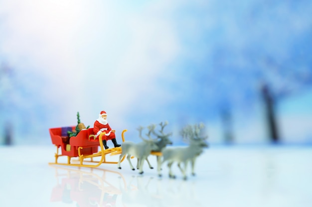 Miniaturowi Ludzie: święty Mikołaj Sanie Reniferowe Z Kartką Okolicznościową Lub Pocztową I Choinką.