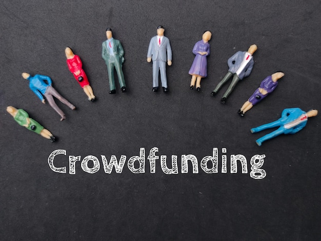 Miniaturowi ludzie ze słowem Crowdfunding Business concept