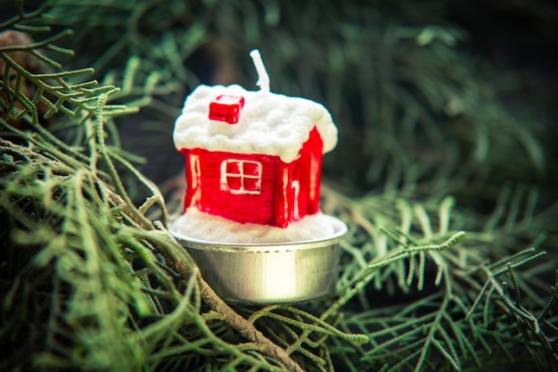 Zdjęcie miniaturowy dom na tle choinki udekorowanej obrazem dla koncepcji inwestycyjnej na nowy rok