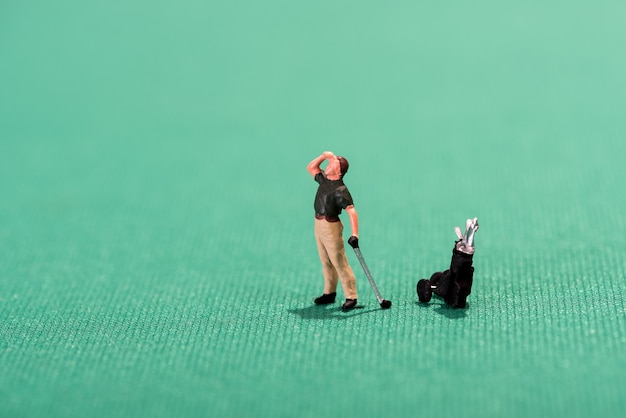 Miniaturowy golfista wpatruje się w dal