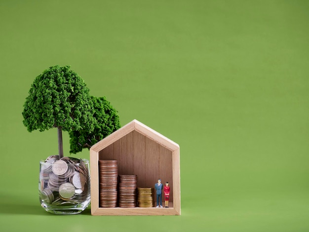 Zdjęcie miniaturowy model domu ze stosami monet