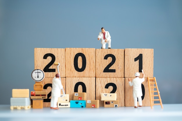 Miniaturowy zespół pracowników pomalował numer 2021 i usunął numer 2020, koncepcja szczęśliwego nowego roku