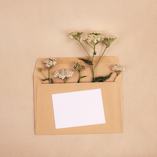 Zdjęcie minimalistyczna pocztówka z bukietem dzikich kwiatów w zbliżeniu koperty
