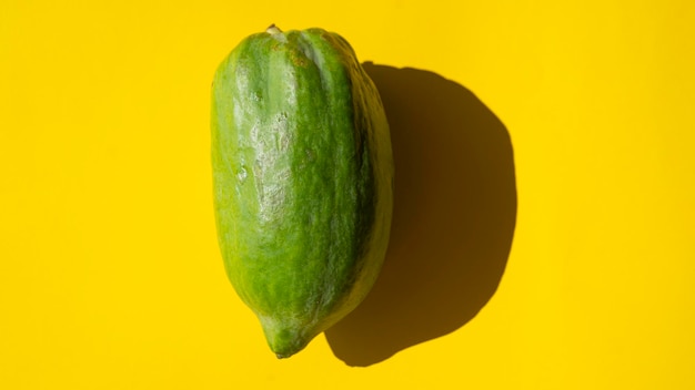 Minimalistyczna zielona papaja na żółtym tle