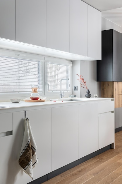Minimalistyczne i nowoczesne białe wnętrze kuchni z meblami i akcesoriami kuchennymi w stylowym wystroju domu Szablon okna Szczegóły