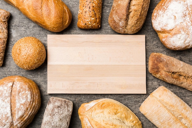 Minimalistyczny drewniany deska do krojenia pusta makieta na tle rodzaje domowego chleba Różne rodzaje świeżego chleba jako tło widok z góry z miejscem na tekst lub projekt
