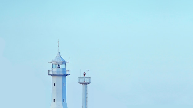 Zdjęcie minimalistyczny obraz latarni na niebieskim tle tapeta z wieżą na niebie