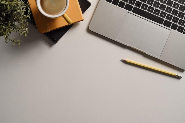 Zdjęcie minimalna przestrzeń robocza z widokiem z góry z filiżanką kawy na laptopa i notebookiem