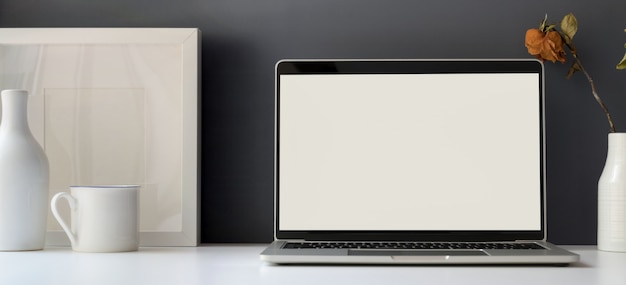 Zdjęcie minimalna sala biurowa z otwartym laptopem z pustym ekranem i pustą ramą