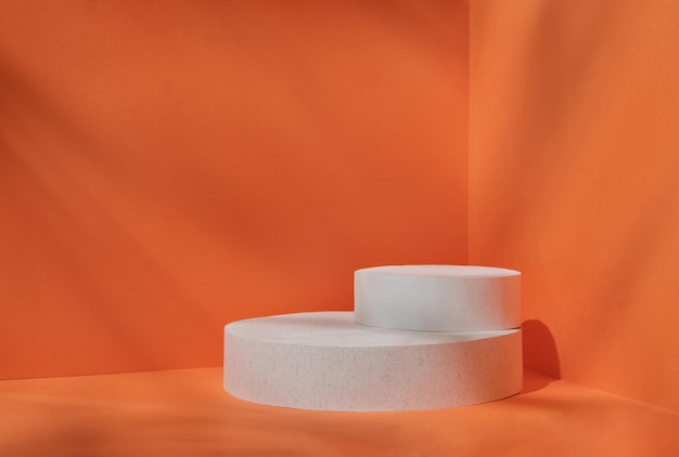 Minimalna scena do nowoczesnej ekspozycji produktu na białej cylindrze podium na pomarańczowym tle
