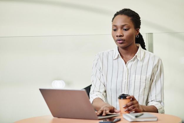 Minimalny Portret Młodej Czarnej Kobiety Korzystającej Z Laptopa Podczas Pracy W Przestrzeni Kopii Budynku Biurowego