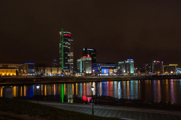 MIŃSK BIAŁORUŚ 7 GRUDNIA 2017 Panorama świateł miasta noc odbicia wieżowca w wodzie jeziora