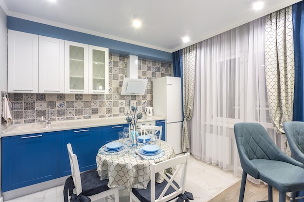 MIŃSK BIAŁORUŚ WRZESIEŃ 2019 Wnętrze nowoczesnej luksusowej kuchni ze stołem gościnnym w apartamentach typu studio w minimalistycznym stylu z niebieskim kolorem