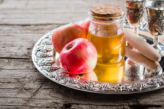 Zdjęcie miód i jabłka na pięknej tacy na drewnianym stołowym tle. żydowskie wakacje rosh hashanah concept