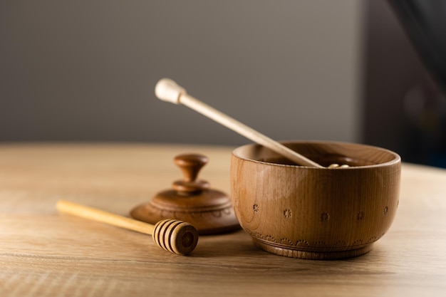 Miód z drewnianą łyżką miodu w drewnianej misce na drewnianym stole.