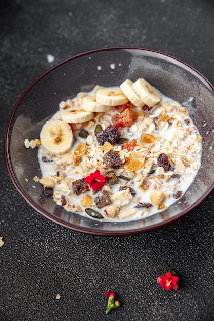 Zdjęcie miska granoli z mlekiem, suszonymi owocami i świeżymi bananami smaczne śniadanie gotowe do spożycia zdrowego posiłku