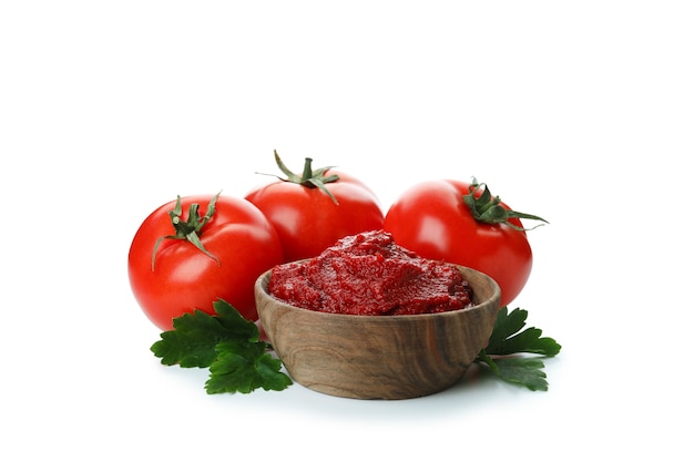 Miska koncentratu pomidorowego i pomidorów na białym tle na białej powierzchni