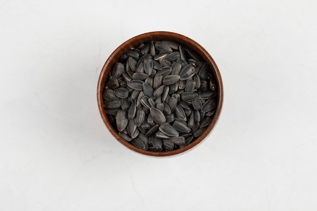 Miska prażonych nasion słonecznika czarnego na białej powierzchni