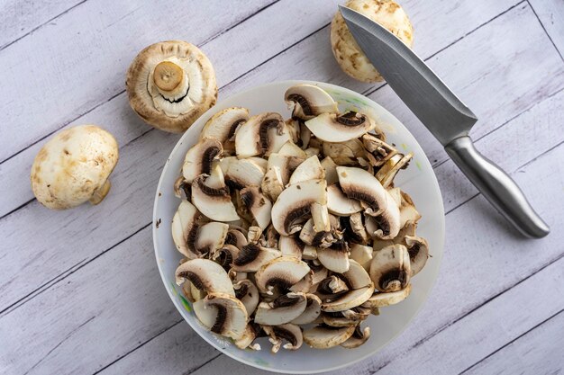 Miska z kawałkami świeżych grzybów pokroić grzyby nożem