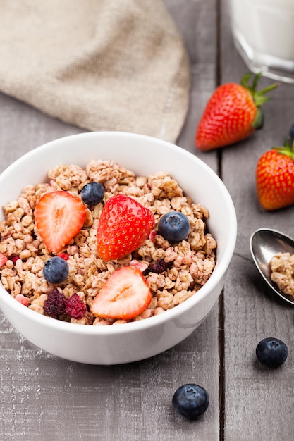 Miska Zdrowych Muesli Zbożowych Z Truskawkami I Jagodami I Szklankę Mleka Na Desce