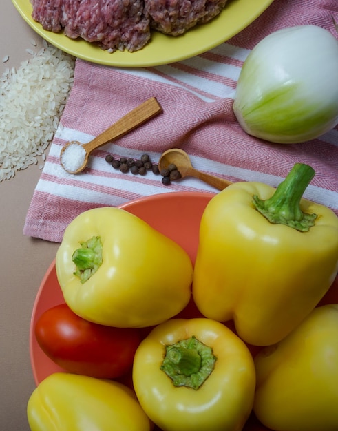 Miska żółtej papryki z czerwonym pomidorem na wierzchu.