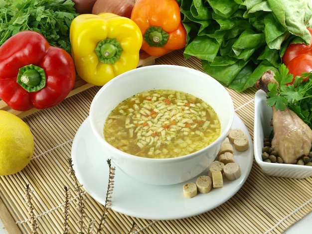 Miska zupy z fasolą i innymi warzywami na stole.