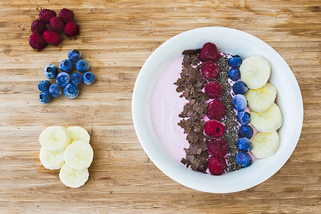 Miski smoothie ze świeżymi jagodami, bananami, nasionami chia i czekoladą na zdrowe śniadanie