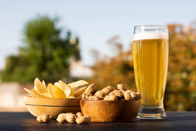 Miski z frytkami i orzeszkami ziemnymi oraz szklanka do piwa