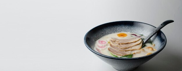 Miso Ramen Azjatycki makaron z jajkiem wieprzowym i kapustą pak choi w misce na białym tle