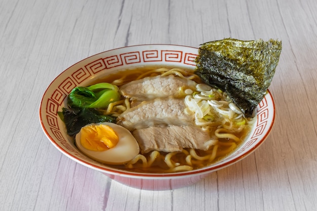 Zdjęcie miso ramen makaron z wieprzowiną na drewnianym stole biały