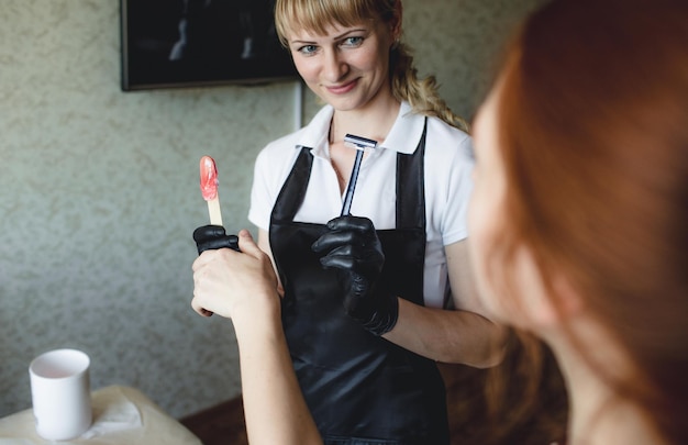 Mistrz depilacji trzyma w rękach brzytwę