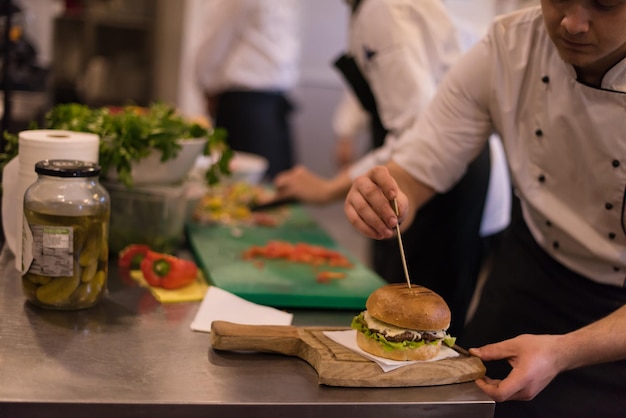 mistrz kuchni kładzie wykałaczkę na burgera w kuchni